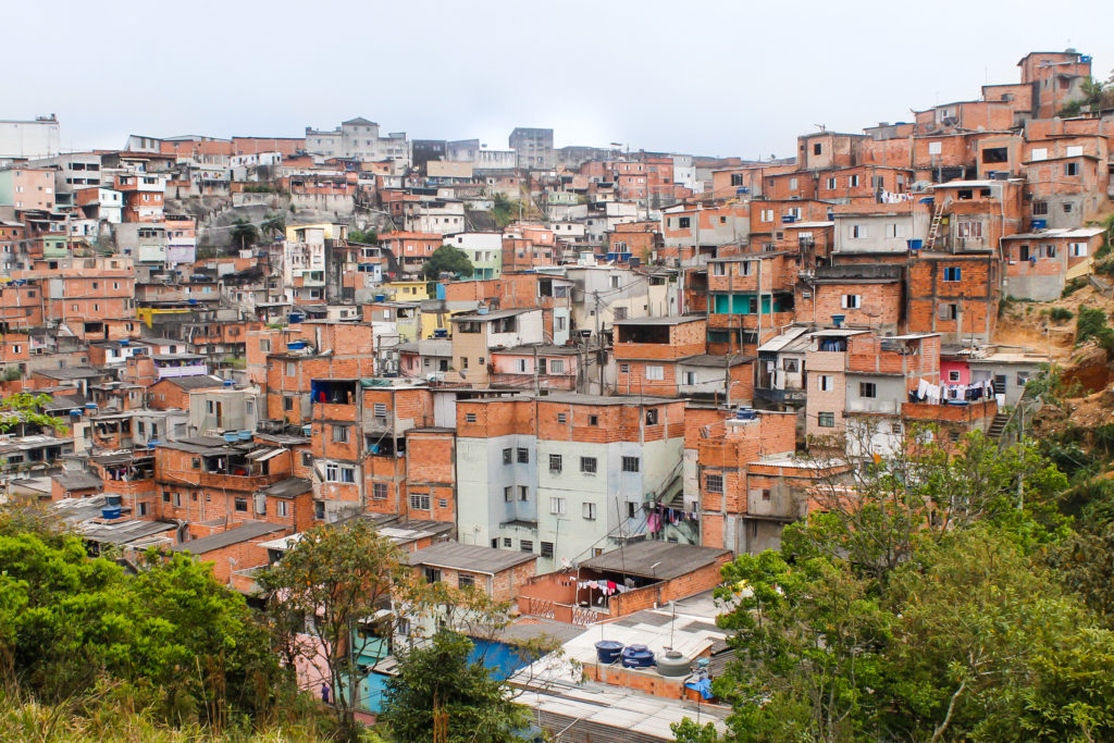 A view of a neighborhood full of small, simple row houses made of brick and concrete.