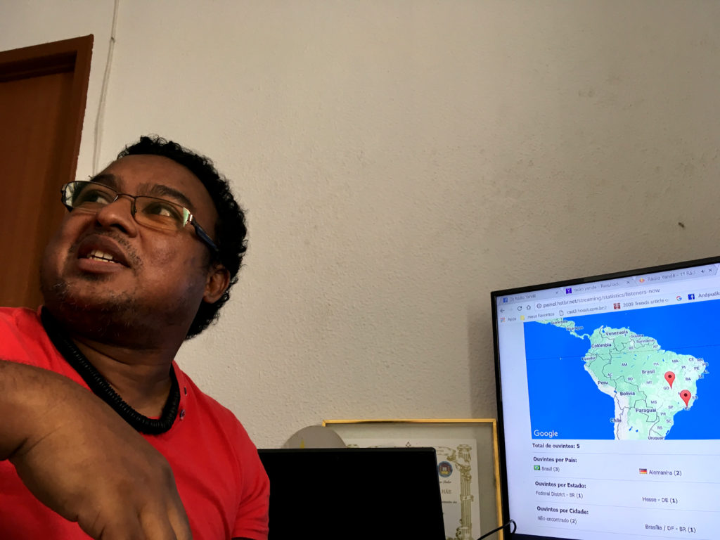 A 43-year-old dark-skinned man with wavy, black hair in front of a computer monitor. On the screen, a map of Brazil is displayed.