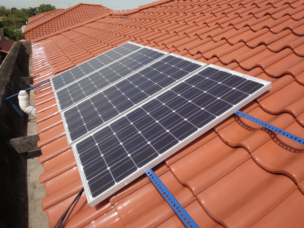 Foto do telhado de uma casa onde parte dele tem 10 placas retangulares fotovoltaicas.
