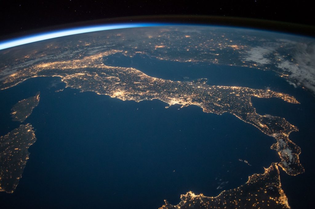 Imagem do Planeta Terra, visto de cima, onde é possível ver o oceano azul, alguns continentes e o fundo preto do universo.